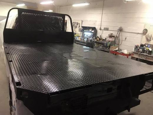 The flatbed sprayed black, diamond plate deck