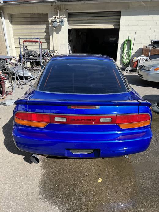 A blue 240SX from the rear